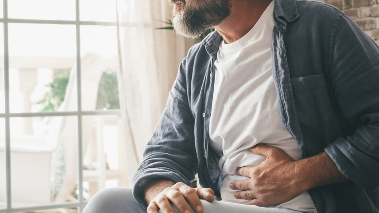 A man holding stomach in pain