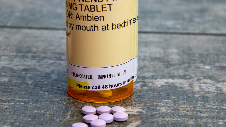 bottle of Ambien with purple pills in front