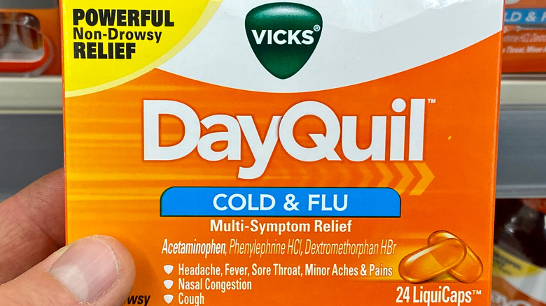 Hand holding box of Dayquil capsules 