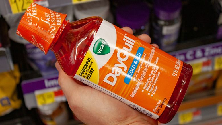Hand holding bottle of Dayquil