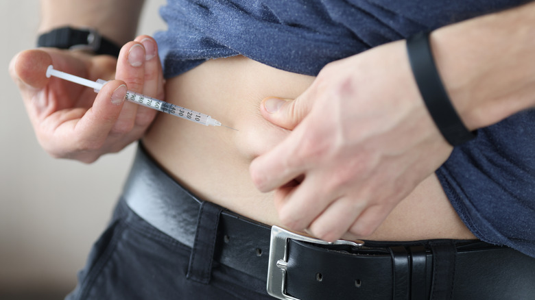 person administering insulin shot