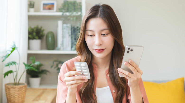 A woman looking at the label of her medication
