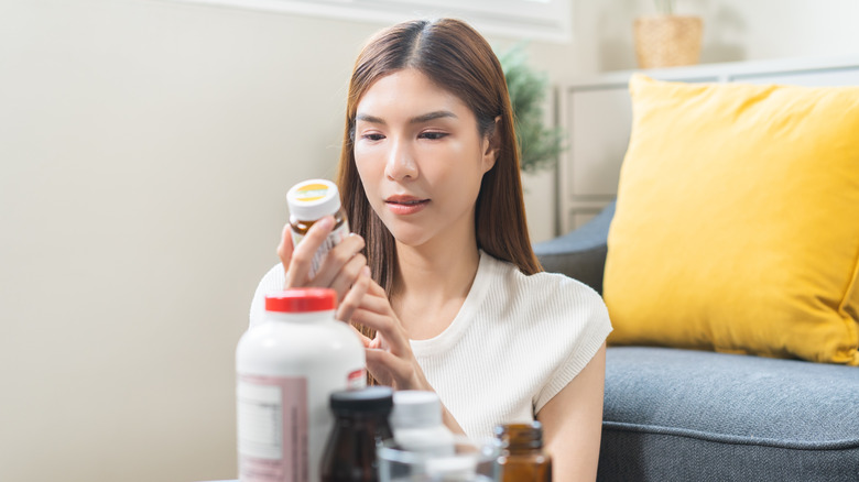 A woman looking at a supplement label