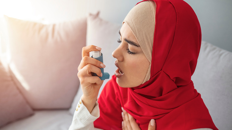 Hijabi woman using inhaler