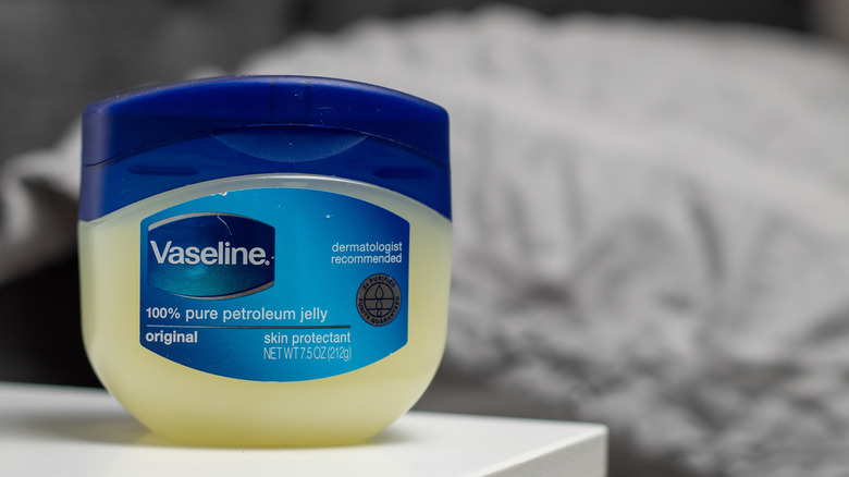 Container of Vaseline on bedside table 