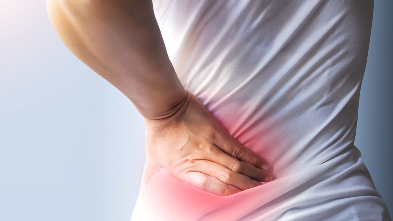 woman holding her back indicating nerve pain