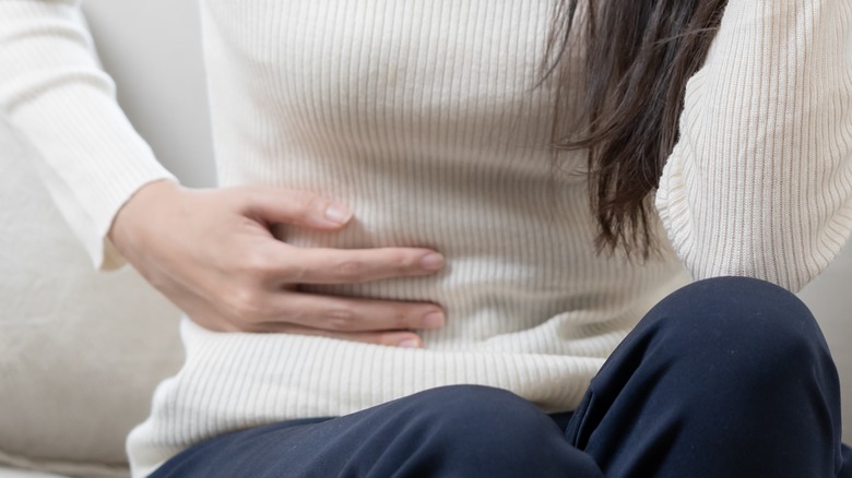 woman with constipation on couch