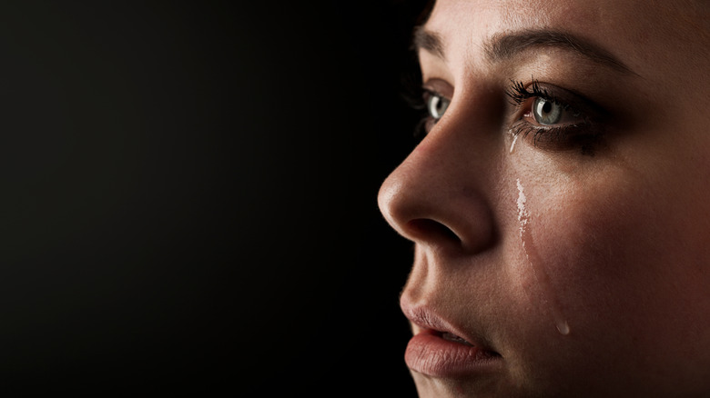 grieving woman crying with black background