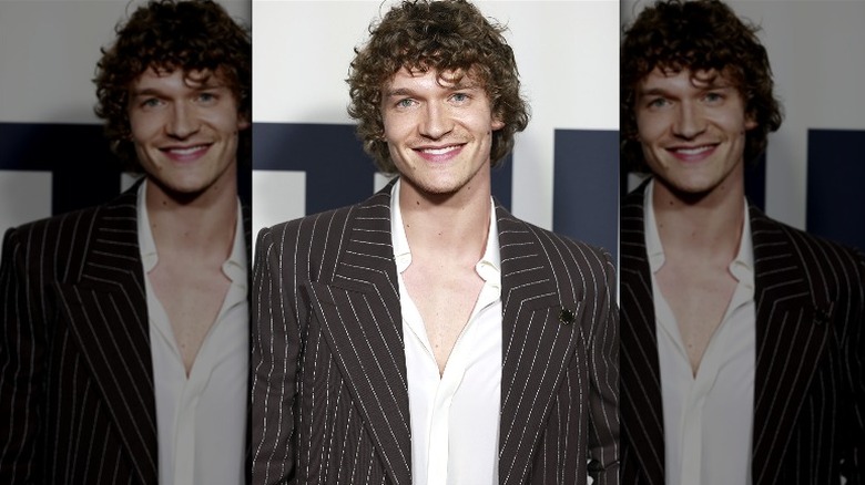 Male with half shaven beard and chest peering into a mirror