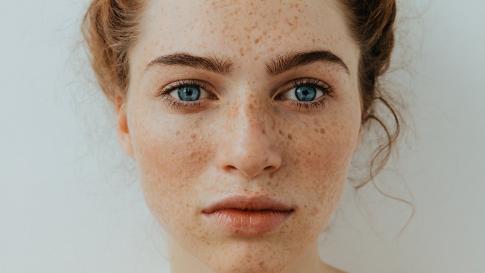 Young woman with red hair, blue eyes, and freckles