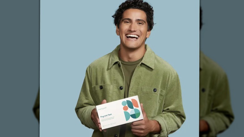 Smiling man holding EverlyWell test kit
