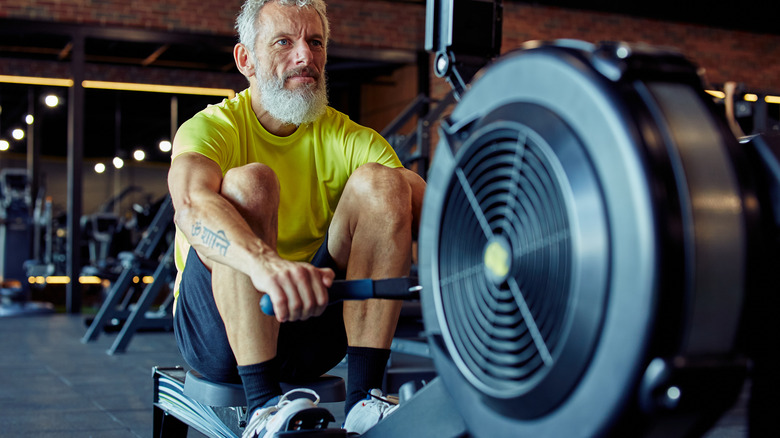 older man on row machine