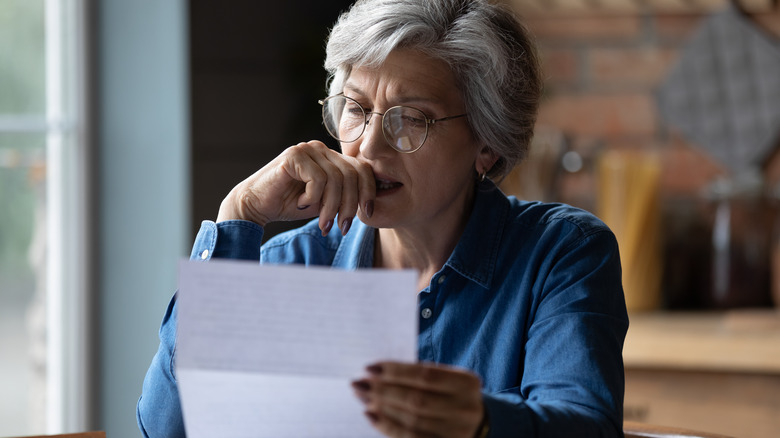 Woman reads paper in concern