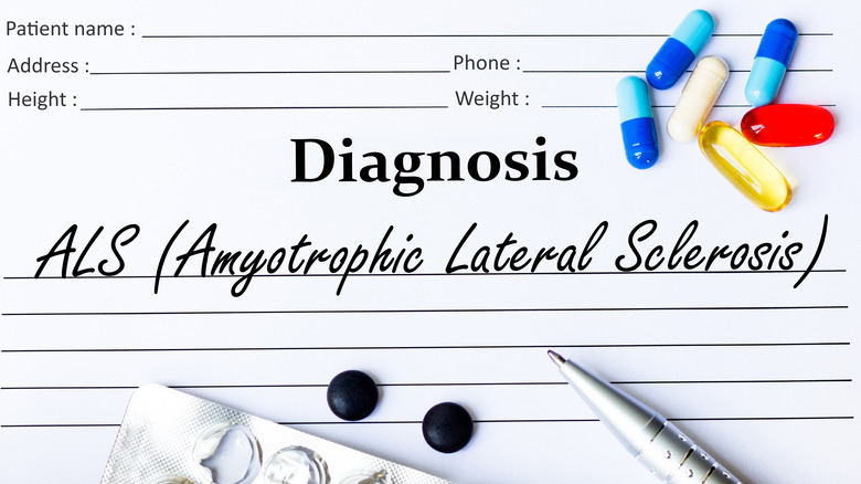 Physician diagnosis paperwork reading "ALS (Amyotrophic Lateral Sclerosis" surrounded with pen and drug capsules