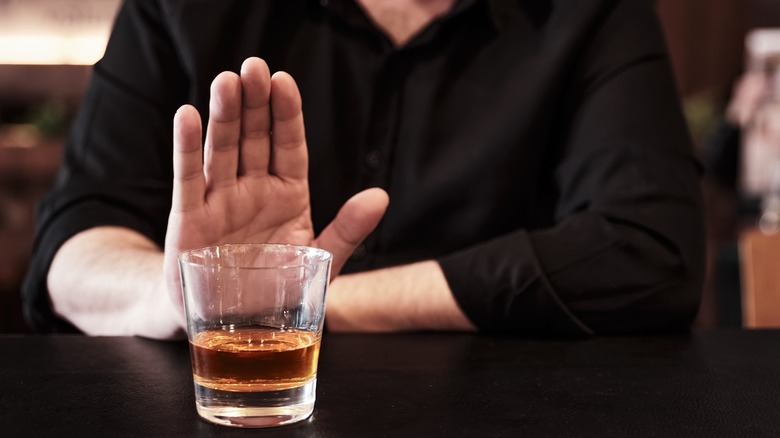 Man pushing away alcoholic drink