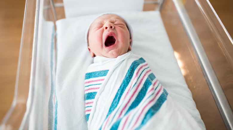 yawning infant in hospital nursery