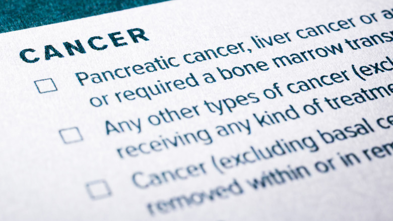 Medical history paperwork with checklist questions about cancer