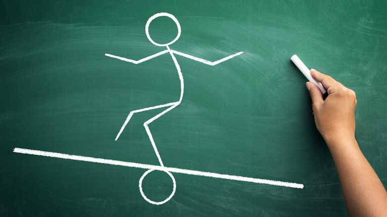chalk drawing of stick man on balance beam
