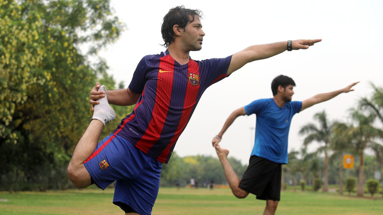 men balancing on one leg