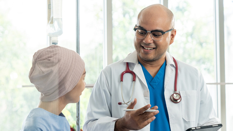 Smiling doctor speaking to smiling cancer patient