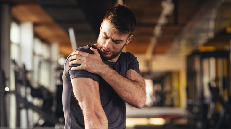 Man having shoulder pain in gym