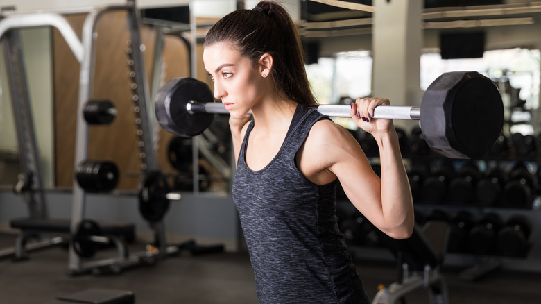 Woman performing behind-the-neck presses