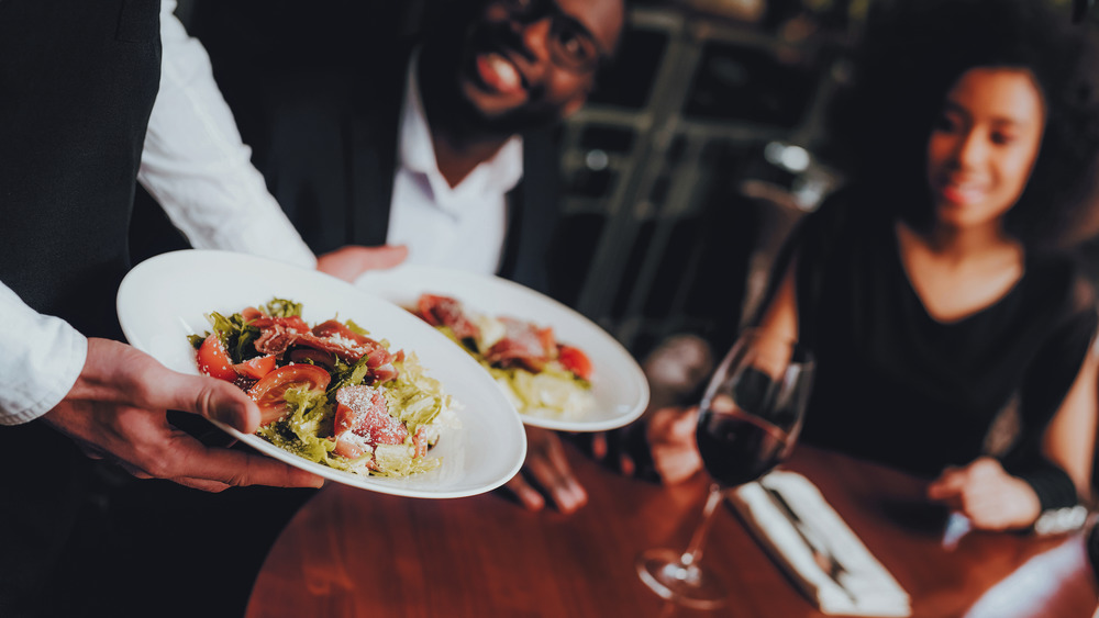 Couple being served dinner at restaurant