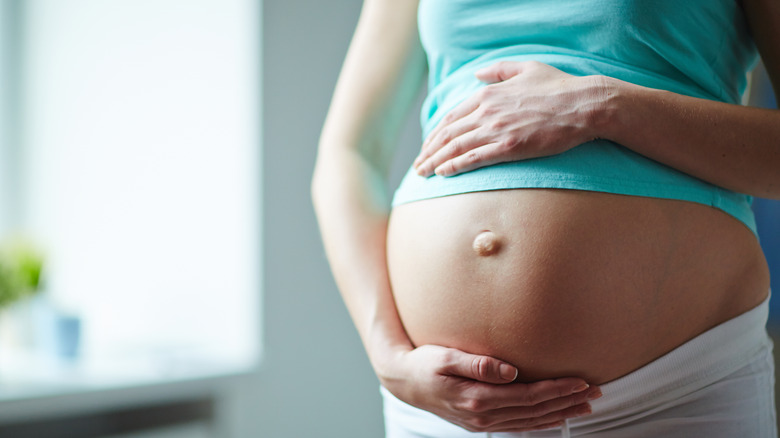 pregnant woman holding her belly