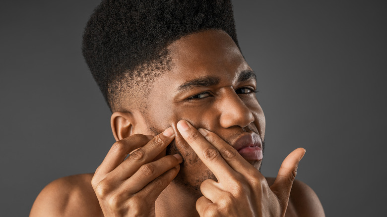 Woman wincing from painful breakout