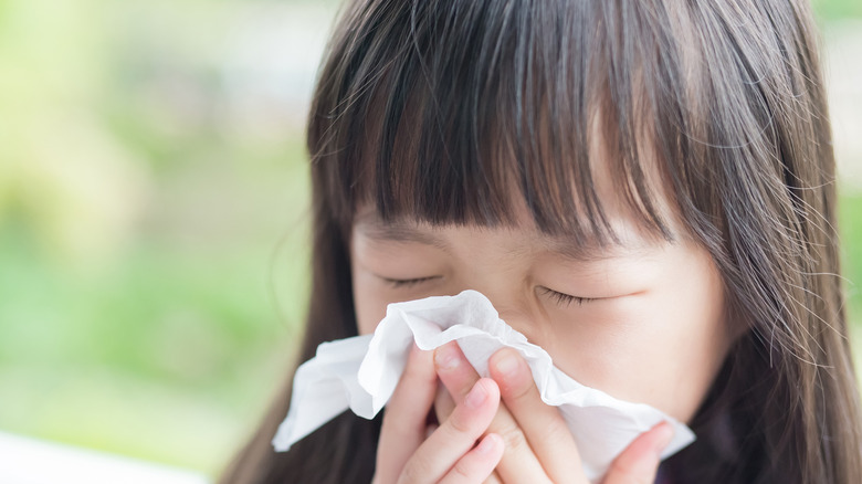 Little girl blowing nose