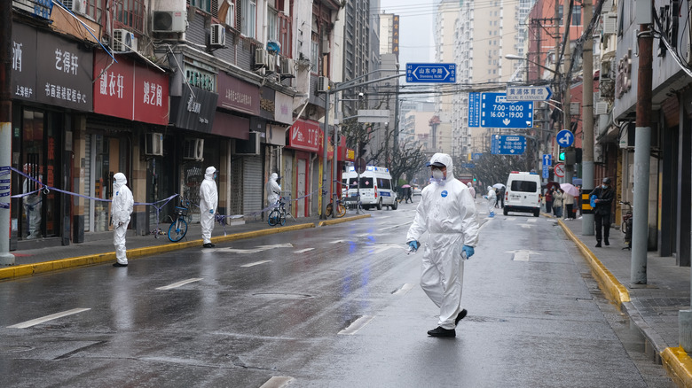 people walking in bio suits in street