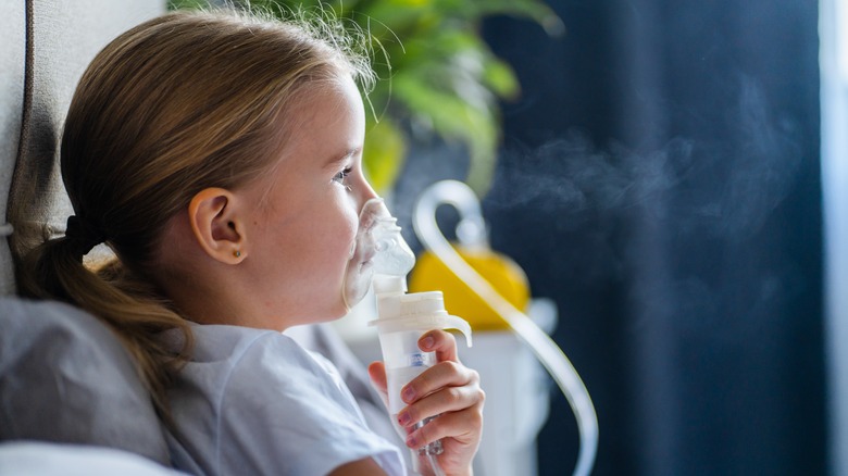 Child with assisted breathing machine