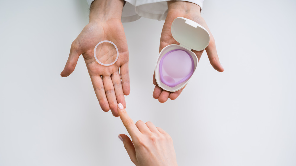 Female hand choosing between contraceptive options