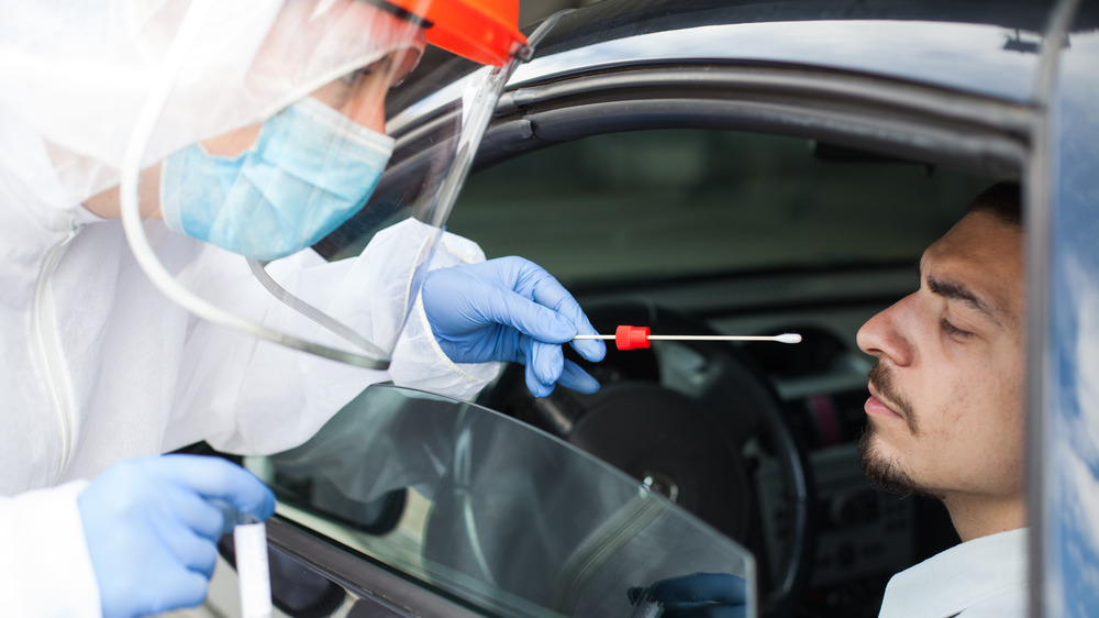 Stock photo of a man getting a drive-through COVID-19 test