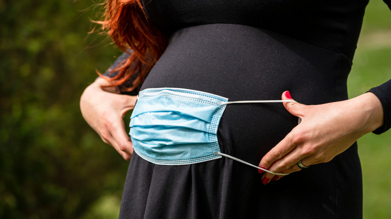 pregnant woman with mask on belly