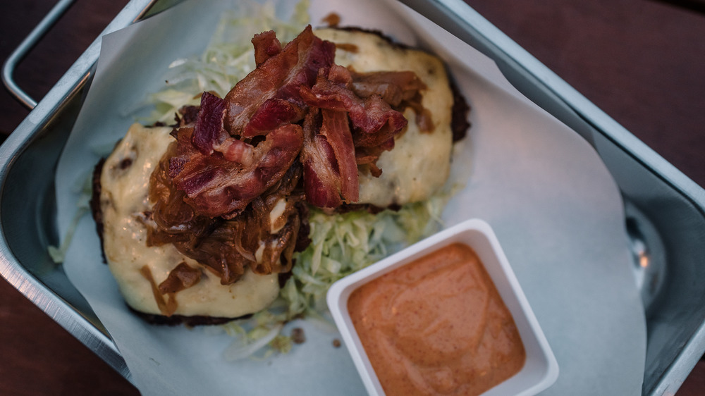 bunless burger with cheese, bacon, and a side of creamy dressing 