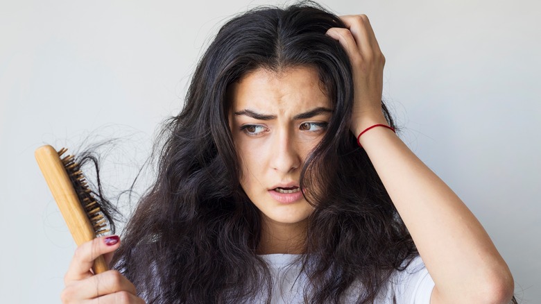 woman losing her hair in brush