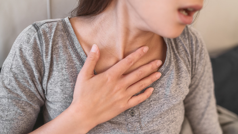 Woman inhaling with hand to chest 