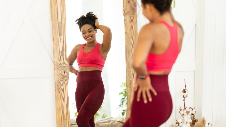 a woman posing in front of the mirror