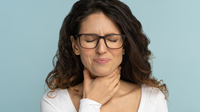 Woman clutching her throat