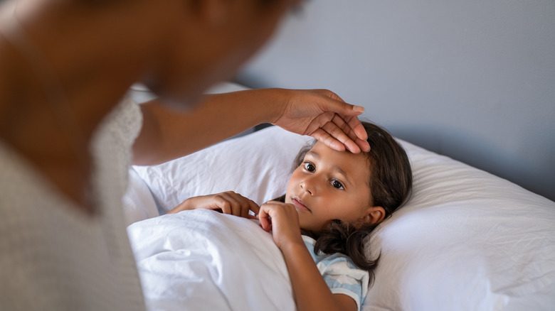 mother checking temperature of child 