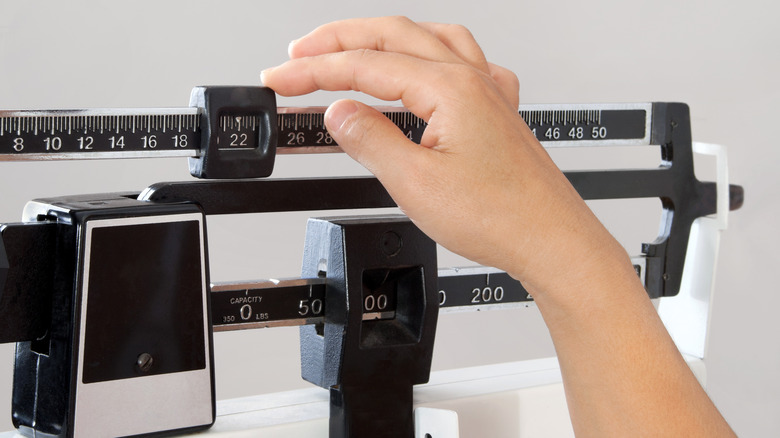 Hand adjusts body weight scale