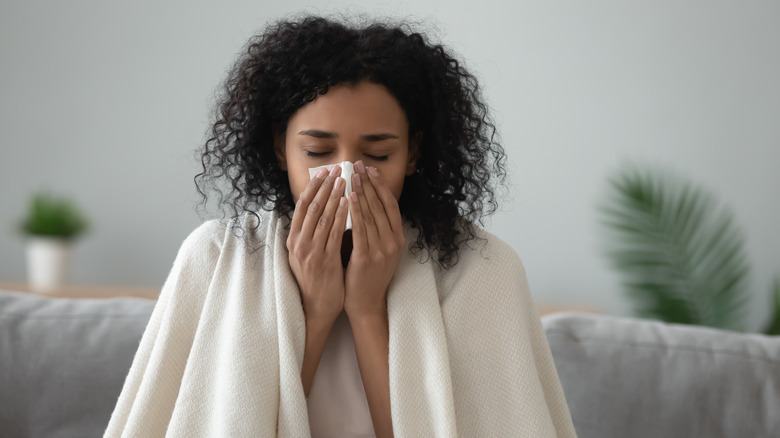 woman blowing nose with tissue