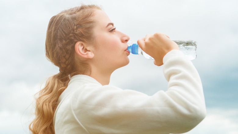 Woman drinking from water bottle