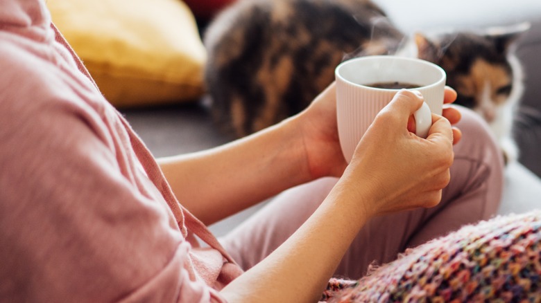 Hands holding hot coffee mug