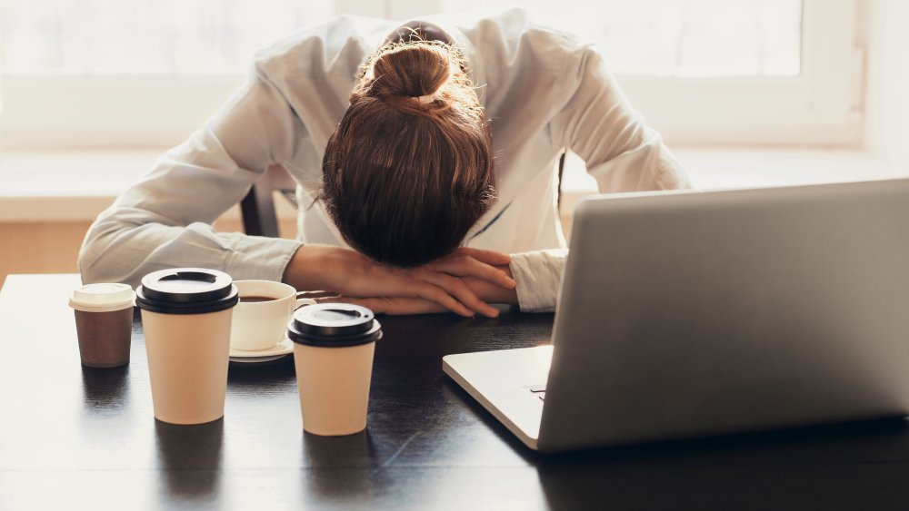 Tired woman with coffee cups