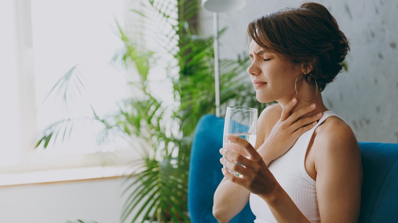 Woman drinking water while choking