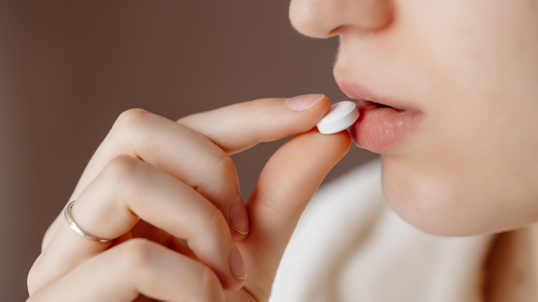 woman taking medicine tablet