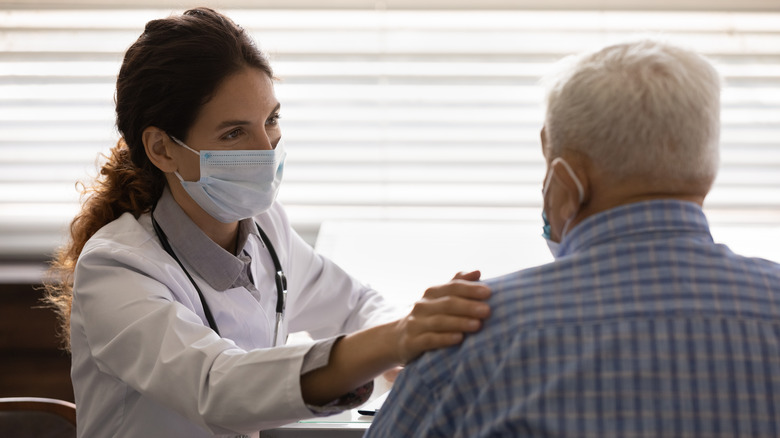 Masked doctor talking to patient