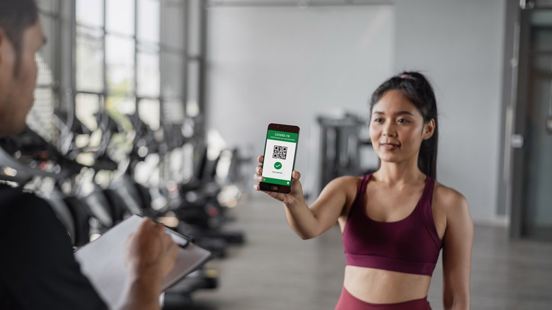 Woman showing vaccination proof at gym